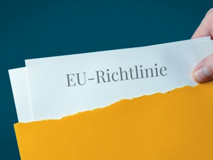 EU-Richtlinie. Brief-Umschlag (gelb) öffnen. Hand zieht Dokument heraus